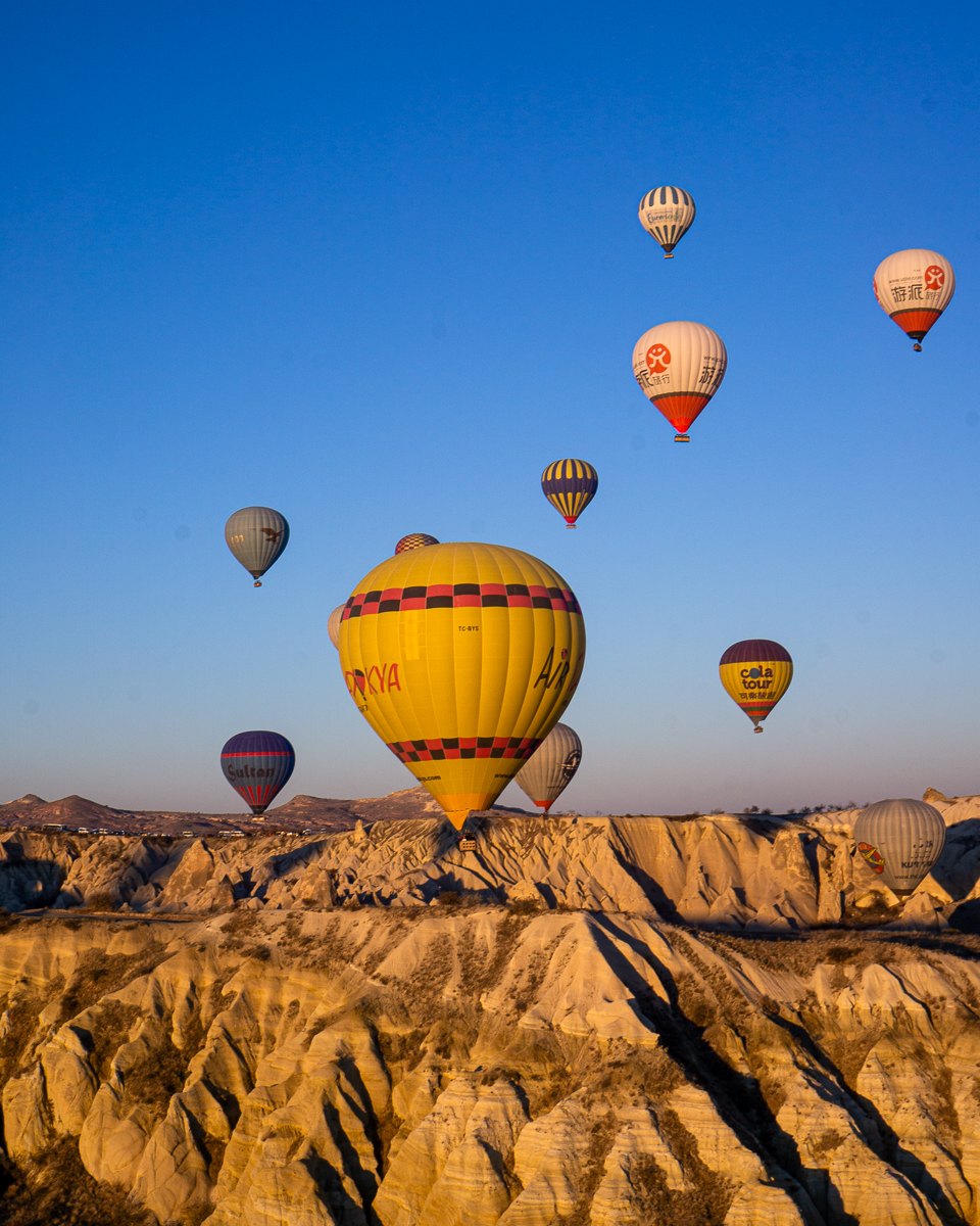 Hot air balloons rising over the rock valleys of Cappadocia, Turkey at sunrise