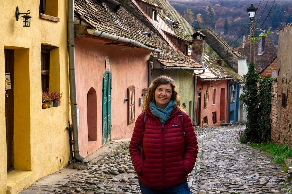 Mairin on a cobbled lane of colourful medieval houses in Sighisoara, Romania