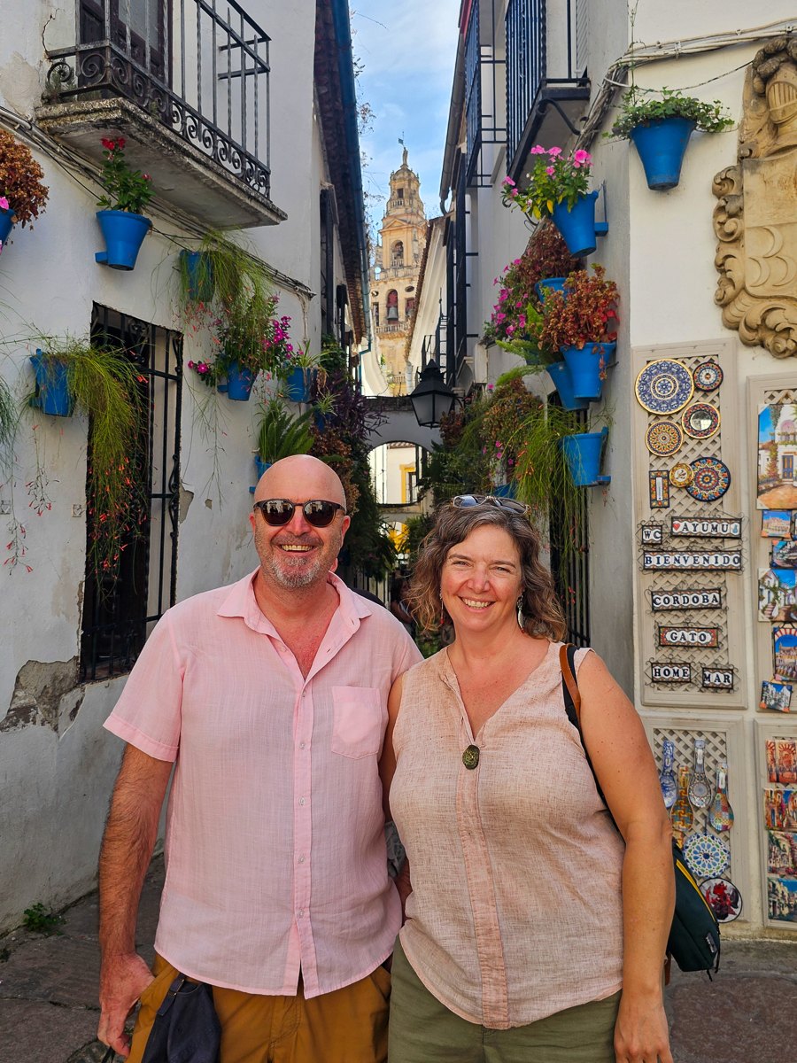 Mairin and Todd in a flower-lined alley in Cordoba, Spain