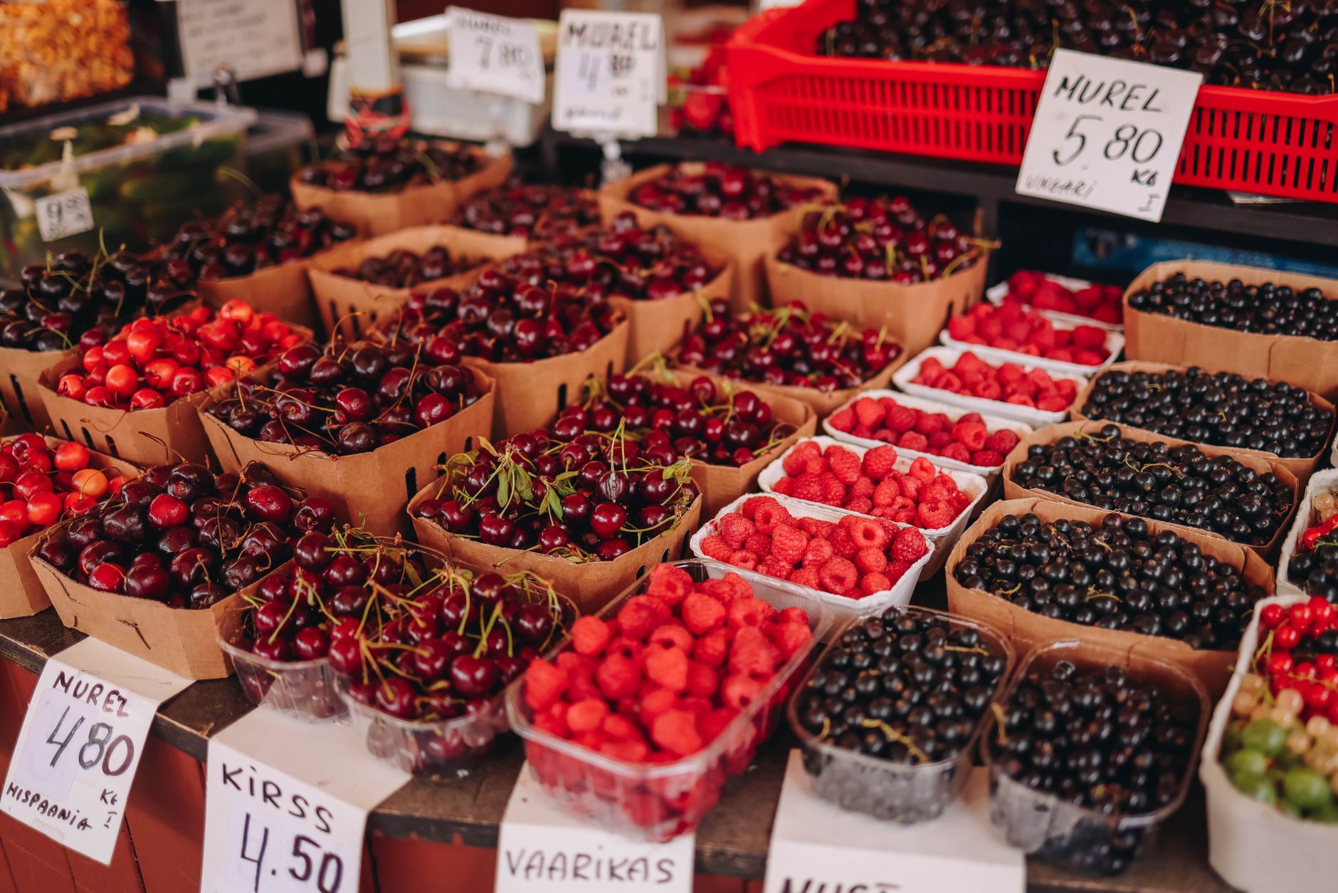 A market stall of cherries and berries in deep reds
