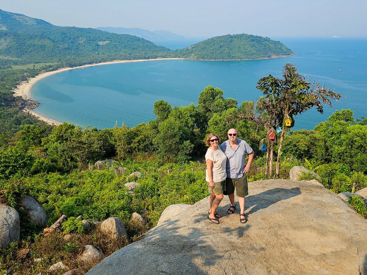 Mairin and Todd on a rocky outcrop above a crescent bay on the Vietnamese coast