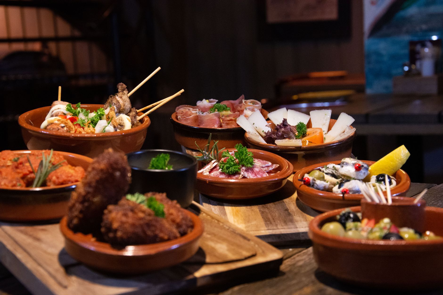 An assortment of Spanish tapas served in small terracotta dishes